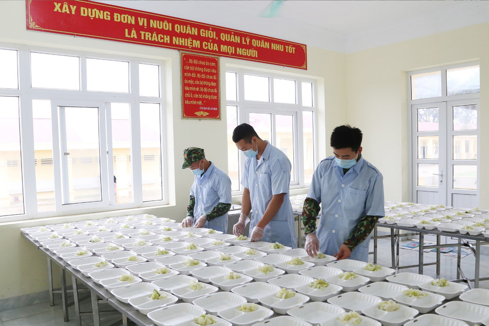 Anh nuôi của các đơn vị quân đội chuẩn bị suất ăn đảm bảo dinh dưỡng cho người thực hiện cách ly tập trung tại các đơn vị quân đội. (Ảnh: Dương Giang/TTXVN)