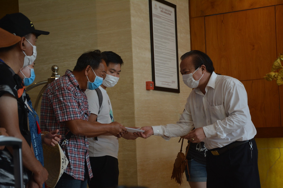 Chủ tịch UBND quận Hải Châu Lê Anh phát giấy chứng nhận hoàn thành cách ly y tế cho các khách cách ly tại khách sạn. (Ảnh: Văn Dũng/TTXVN)