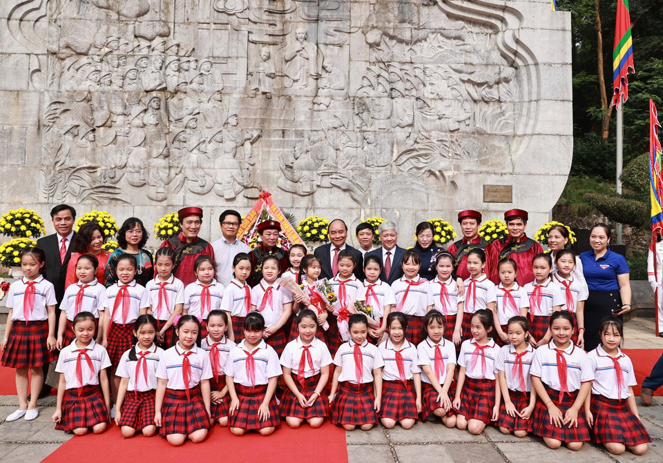 Chủ tịch nước Nguyễn Xuân Phúc với các đại biểu và thiếu nhi tại bức Phù điêu có hình tượng Bác Hồ nói chuyện với các chiến sỹ Đại đoàn quân Tiên phong. (Ảnh: Thống Nhất/TTXVN)