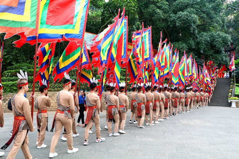 100 thanh niên tượng trưng cho con Lạc, cháu Hồng trong trang phục cổ, tay giương cao cờ hội, thể hiện sức sống mãnh liệt của dòng giống Tiên Rồng. (Ảnh: Trung Kiên/TTXVN)