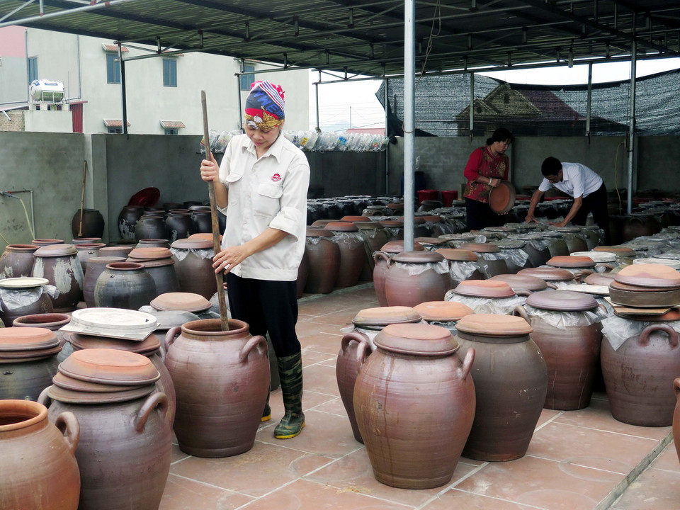 Người dân sử dụng chum sành để ngả tương và sử dụng gậy tre sạch để khuấy đều 2-3 lần/ngày. (Ảnh: Quân Trang/TTXVN)
