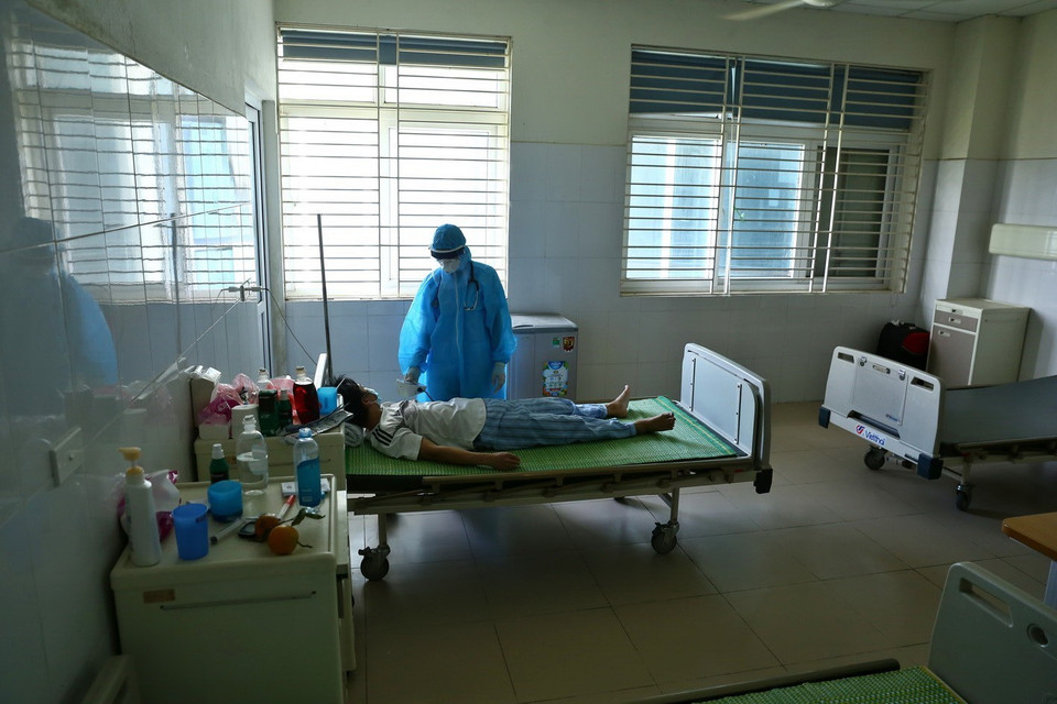 Bác sỹ kiểm tra mạch, huyết áp, độ bão hòa ôxy cho bệnh nhân COVID-19 với tần suất 2 lần/ngày tại Khoa Virus-Ký sinh trùng thuộc Bệnh viện Bệnh Nhiệt đới Trung ương cơ sở 2. (Ảnh: Minh Quyết/TTXVN)