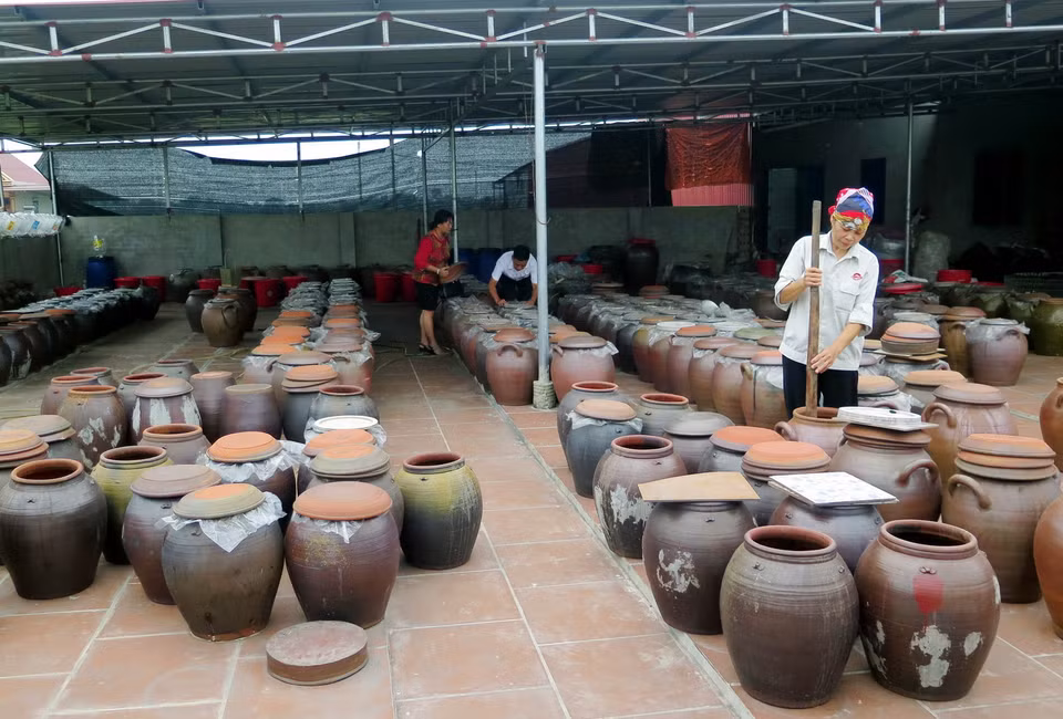 Người dân sử dụng chum sành để ngả tương và sử dụng gậy tre sạch để khuấy đều 2-3 lần/ngày. (Ảnh: Quân Trang/TTXVN)