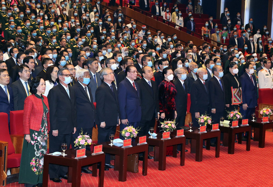 Các vị lãnh đạo, nguyên lãnh đạo Đảng, Nhà nước và đại biểu thực hiện nghi lễ chào cờ. (Ảnh: Thống Nhất/TTXVN)