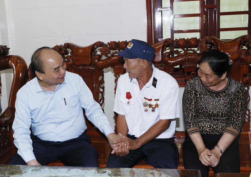 Chủ tịch nước Nguyễn Xuân Phúc thăm, tặng quà thương binh Nguyễn Thống tại thôn Mỹ Cảnh, xã Bảo Ninh, thành phố Đồng Hới. (Ảnh: Thống Nhất/TTXVN)