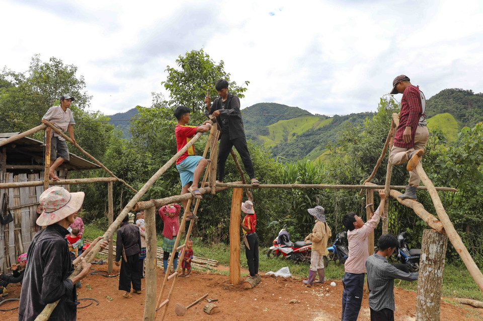 Người dân cùng nhau dựng nhà tạm trong khi chờ bố trí tái định cư. (Ảnh: Xuân Tư/TTXVN)