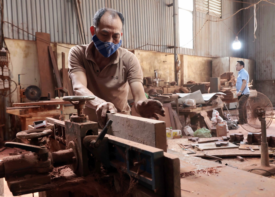 Cơ sở sản xuất đồ gỗ nhà ông Nguyễn Hữu Khuê ở thôn Nhị Khê thu hút hơn 10 lao động. (Ảnh: Trần Việt/TTXVN)