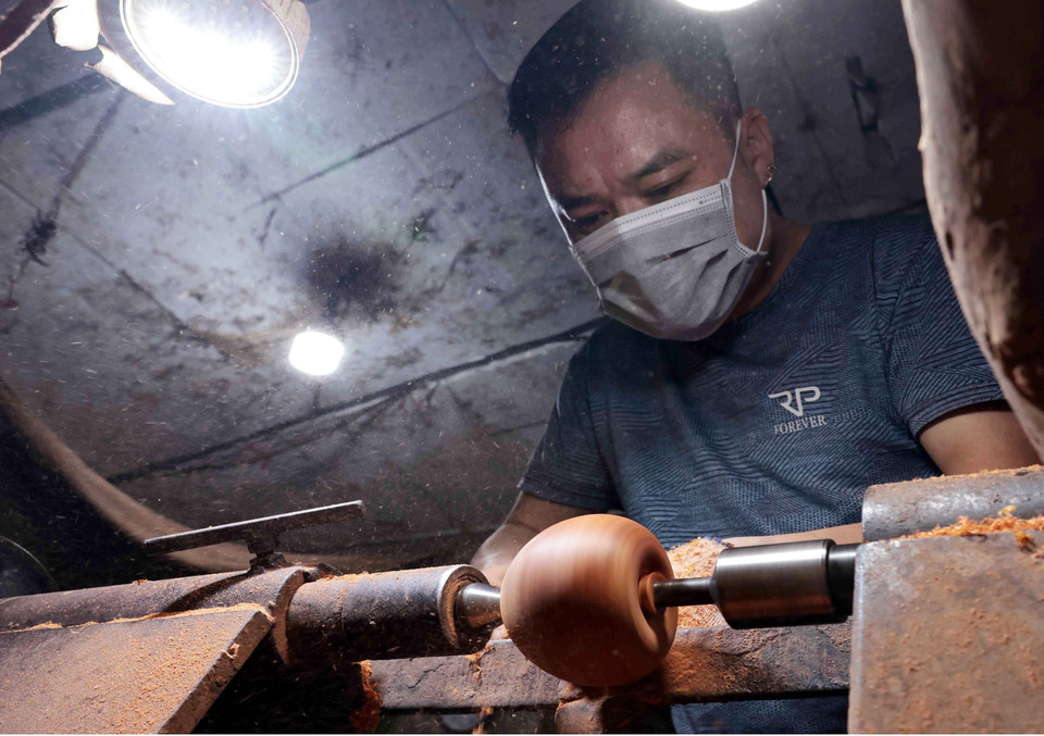 Nghệ nhân đứng máy tiện gỗ. (Ảnh: Trần Việt/TTXVN)