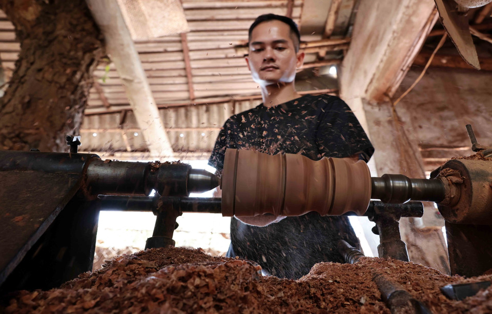 Các nghệ nhân thực hiện tiện ngoài sản phẩm. (Ảnh: Trần Việt/TTXVN)