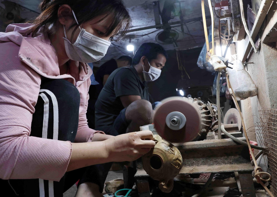 Mài bóng sản phẩm sau khi tiện. (Ảnh: Trần Việt/TTXVN)