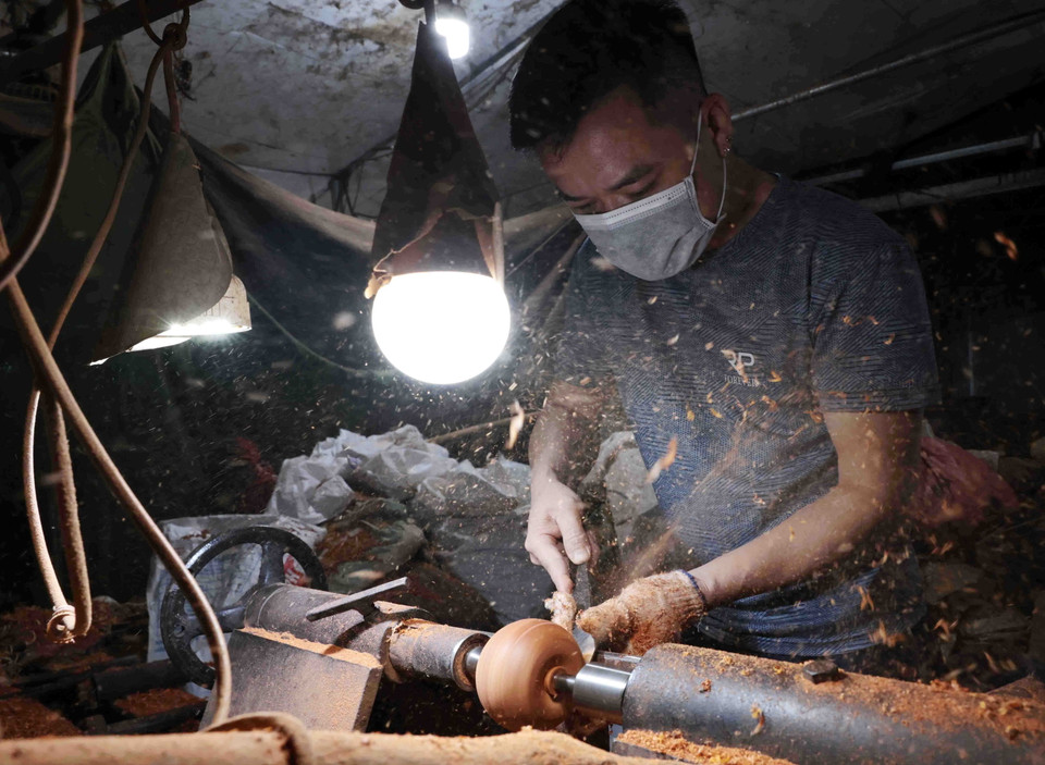 Nghệ nhân đứng máy tiện gỗ. (Ảnh: Trần Việt/TTXVN)