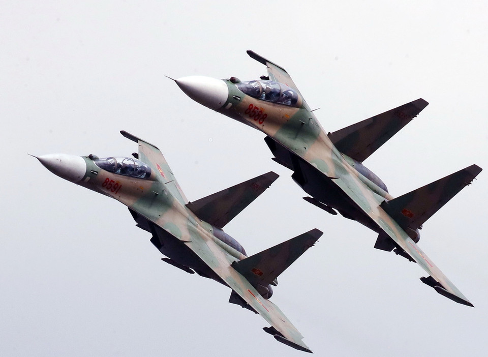 Su30-MK2 nghiêng cánh bay qua khán đài chào mừng các đại biểu dự lễ khai mạc.( Ảnh: TTXVN phát)