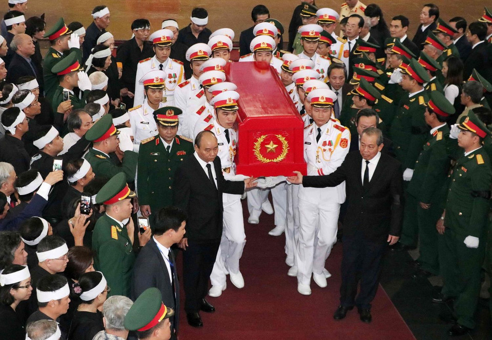 Thủ tướng Nguyễn Xuân Phúc và Phó Thủ tướng Thường trực Trương Hòa Bình chuyển linh cữu đồng chí Đồng Sỹ Nguyên về nơi an nghỉ cuối cùng. (Ảnh: Văn Điệp/TTXVN)