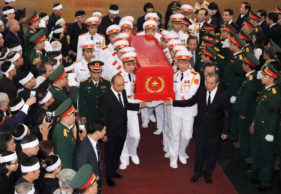 Thủ tướng Nguyễn Xuân Phúc và Phó Thủ tướng Thường trực Trương Hòa Bình chuyển linh cữu đồng chí Đồng Sỹ Nguyên về nơi an nghỉ cuối cùng. (Ảnh: Văn Điệp/TTXVN)