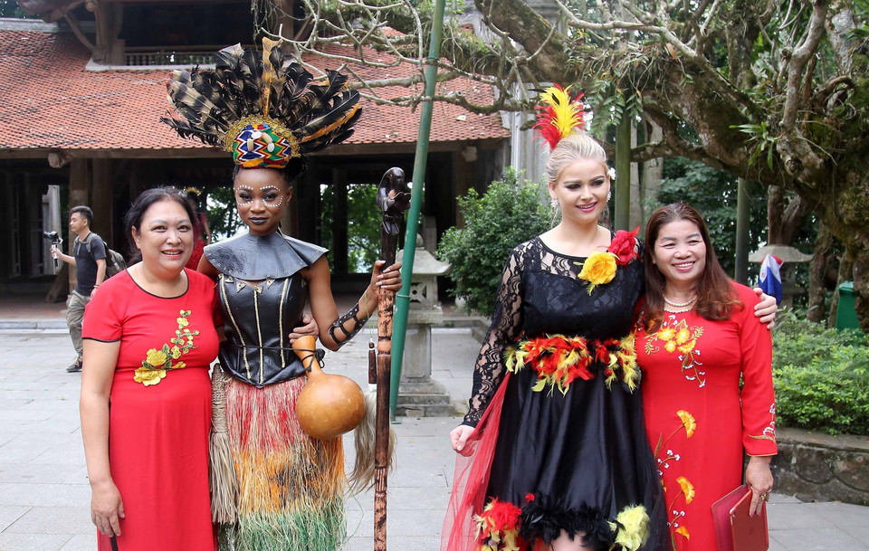 Khách du lịch chụp ảnh lưu niệm với các thí sinh dự Cuộc thi Hoa hậu Du lịch Thế giới 2022 tại Đền Hùng. (Ảnh: Trung Kiên/TTXVN)