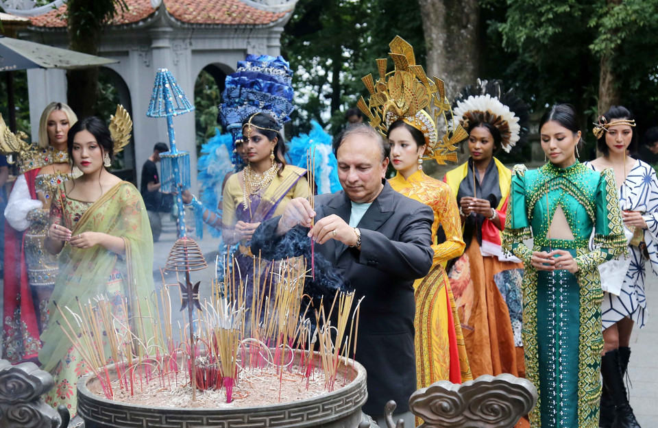 Ông John Singh - Người sáng lập và chủ sở hữu cuộc thi Miss Tourism World (Hoa hậu Du lịch thế giới) - cùng các thí sinh dâng hương tại Đền Hạ. (Ảnh: Trung Kiên/TTXVN)