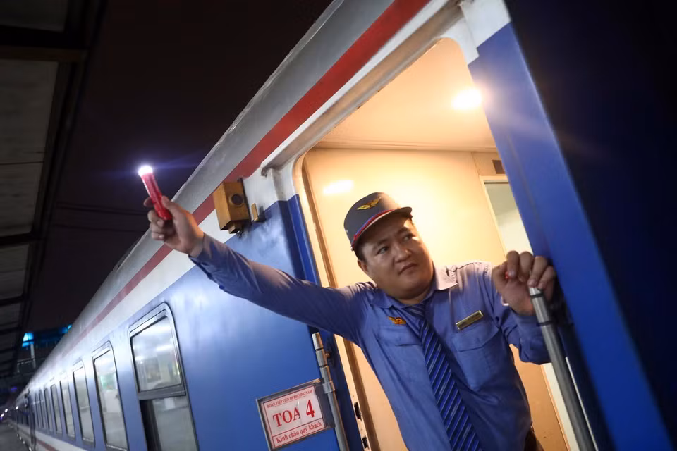 Nhân viên đường sắt ra hiệu lệnh tàu bắt đầu lăn bánh. (Ảnh: Huy Hùng/TTXVN)