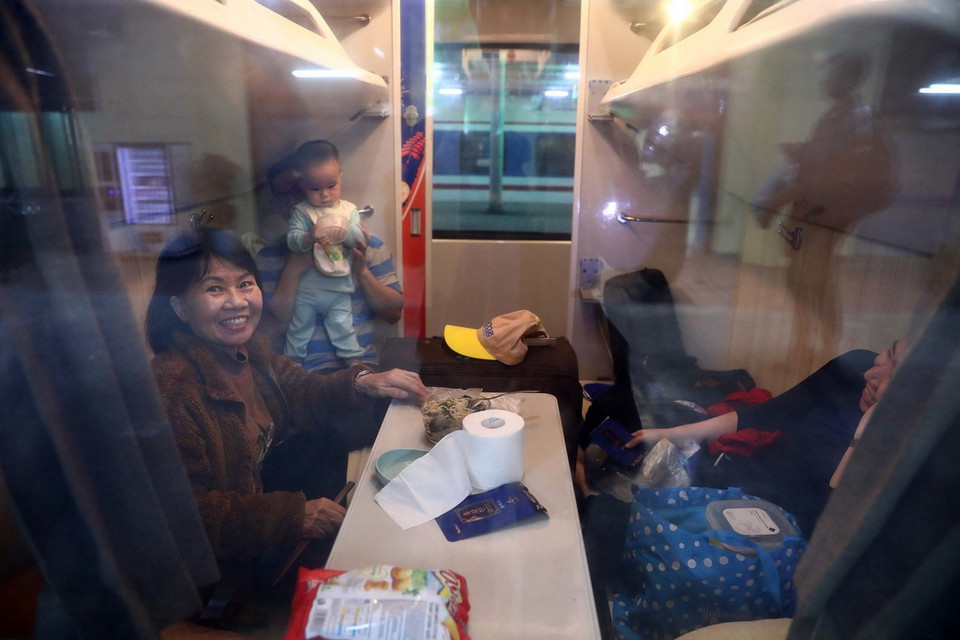 Một gia đình vui vẻ khi chuẩn bị được về nhà ăn Tết. (Ảnh: Huy Hùng/TTXVN)