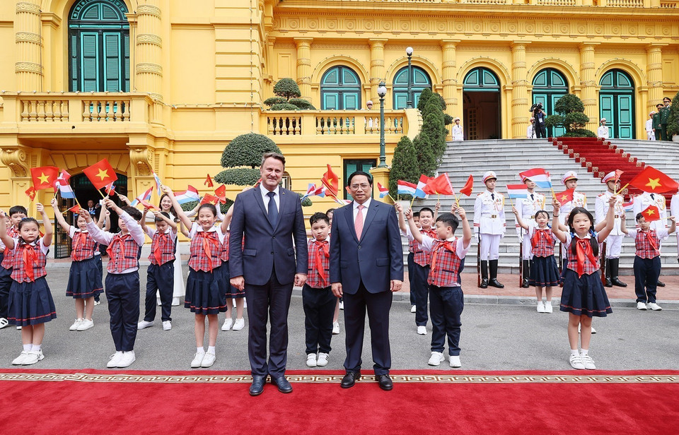 Thủ tướng Phạm Minh Chính và Thủ tướng Đại Công quốc Luxembourg Xavier Bettel với thiếu nhi Thủ đô tại lễ đón. (Ảnh: Dương Giang/TTXVN)