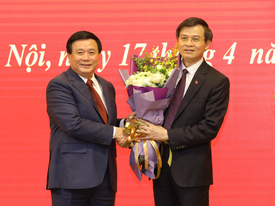 Ủy viên Bộ Chính, Chủ tịch Hội đồng Lý luận Trung ương Nguyễn Xuân Thắng tặng hoa Ủy viên Trung ương Đảng, Tổng biên tập Tạp chí Cộng sản Đoàn Minh Huấn. (Ảnh: Văn Điệp/TTXVN)