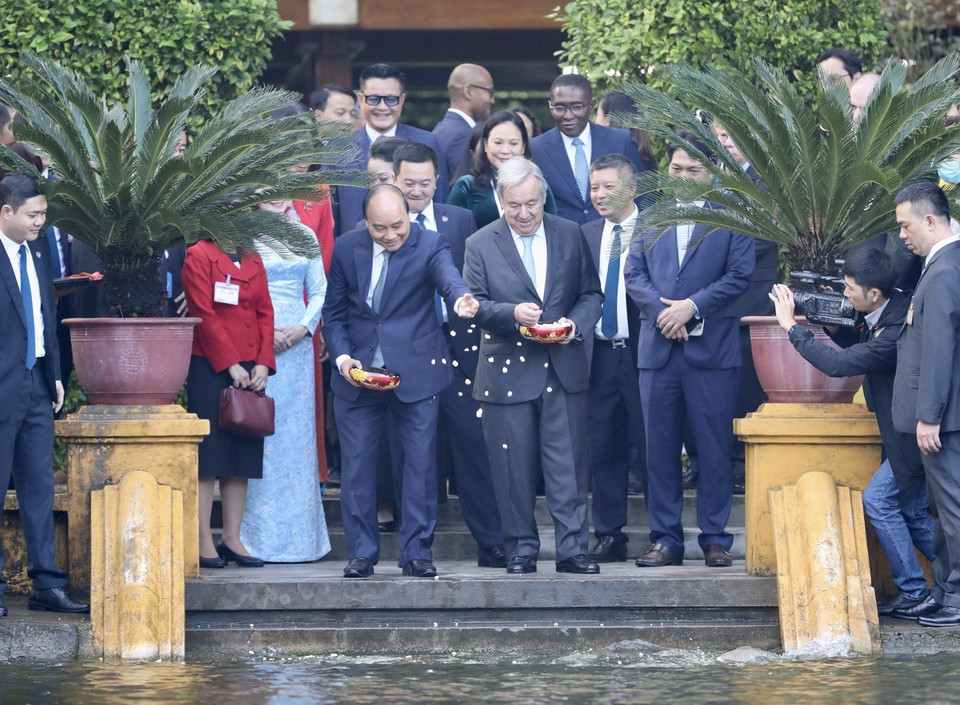 Chủ tịch nước Nguyễn Xuân Phúc và Tổng Thư ký Liên Hợp Quốc António Guterres cho cá ăn tại Ao cá Bác Hồ. (Ảnh: Lâm Khánh/TTXVN)