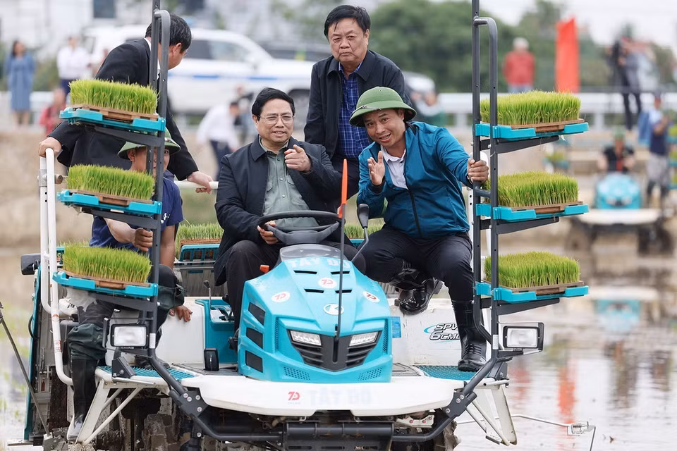 Thủ tướng Phạm Minh Chính cùng nông dân gieo mạ vụ Đông Xuân bằng phương tiện cơ giới. (Ảnh: Dương Giang/TTXVN)