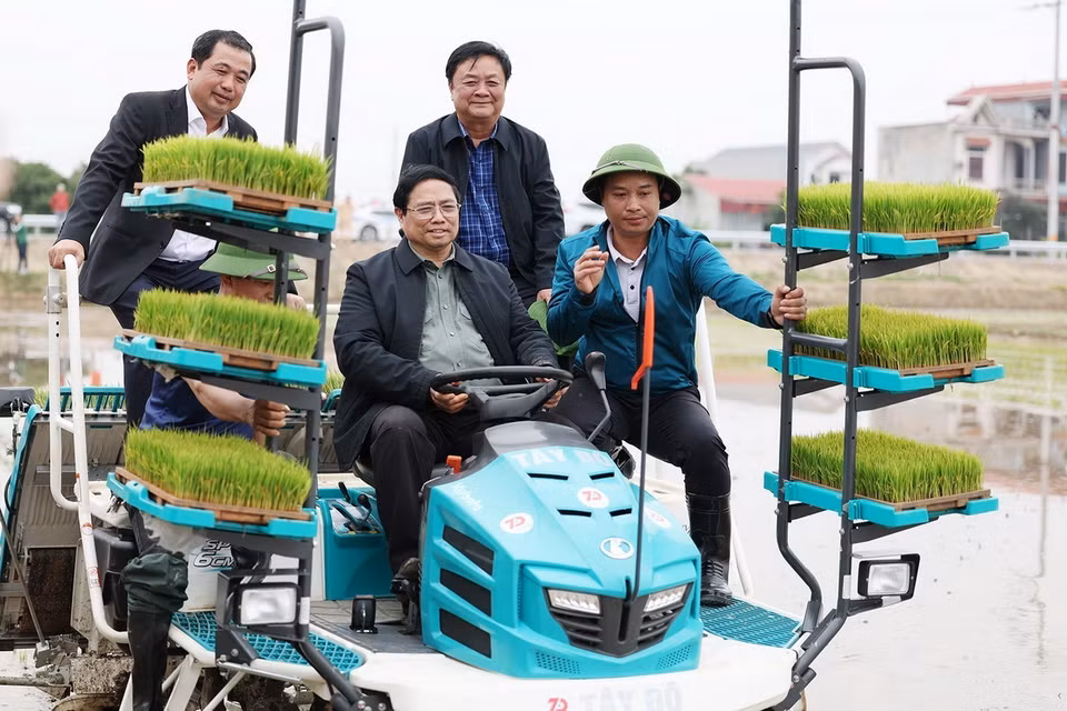 Thủ tướng Phạm Minh Chính cùng nông dân gieo mạ vụ Đông Xuân bằng phương tiện cơ giới. (Ảnh: Dương Giang/TTXVN)