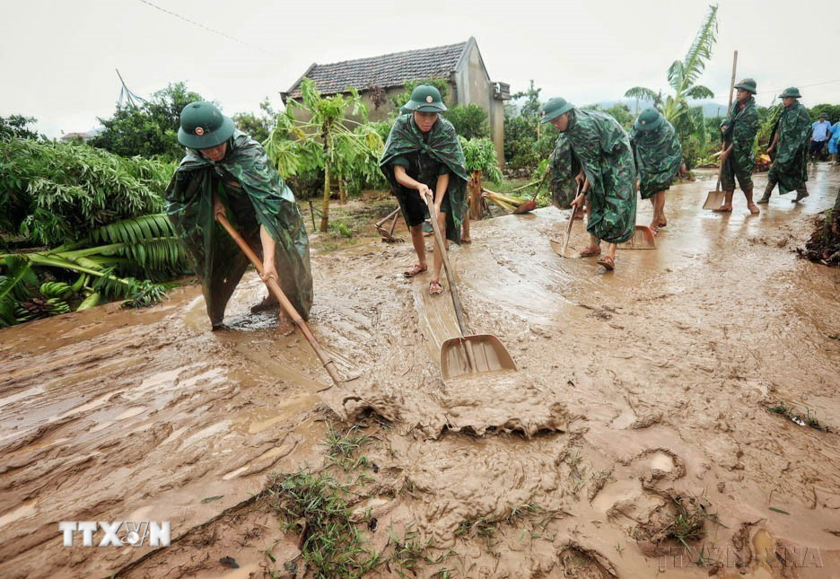 Cán bộ, chiến sỹ Sư đoàn 325 dọn dẹp sình lầy tại thôn Khả Lã, xã Tân Lập, huyện Lục Ngạn, tỉnh Bắc Giang, để người dân sớm ổn định cuộc sống sau bão lũ ngày 13/9 vừa qua. (Ảnh: Danh Lam/TTXVN)