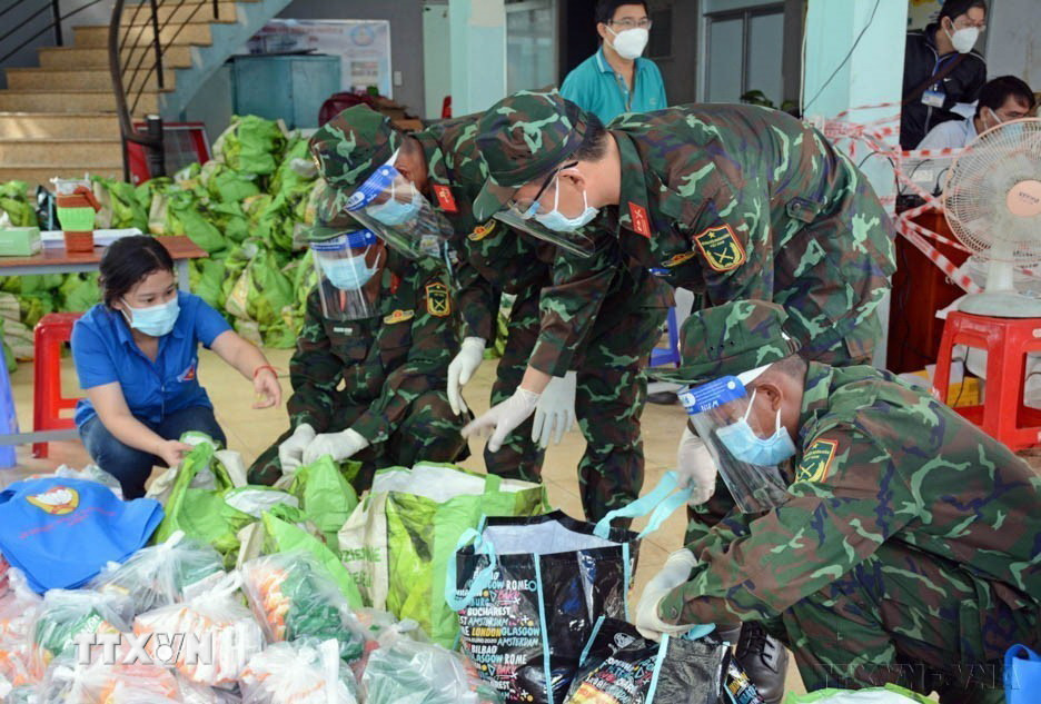 Dịch COVID-19 bùng phát tại Thành phố Hồ Chí Minh đã xuất hiện hình ảnh những người lính bộ đội Cụ Hồ trên nhiều tuyến đường, ngõ hẻm, khu phong tỏa, điểm cách ly… năng nổ, nhiệt tình, xông pha để giúp người dân, hỗ trợ chính quyền khi cả Thành phố giãn cách xã hội “ai ở đâu, ở yên đó,” tháng 8/2021. (Ảnh: Thanh Vũ/TTXVN)