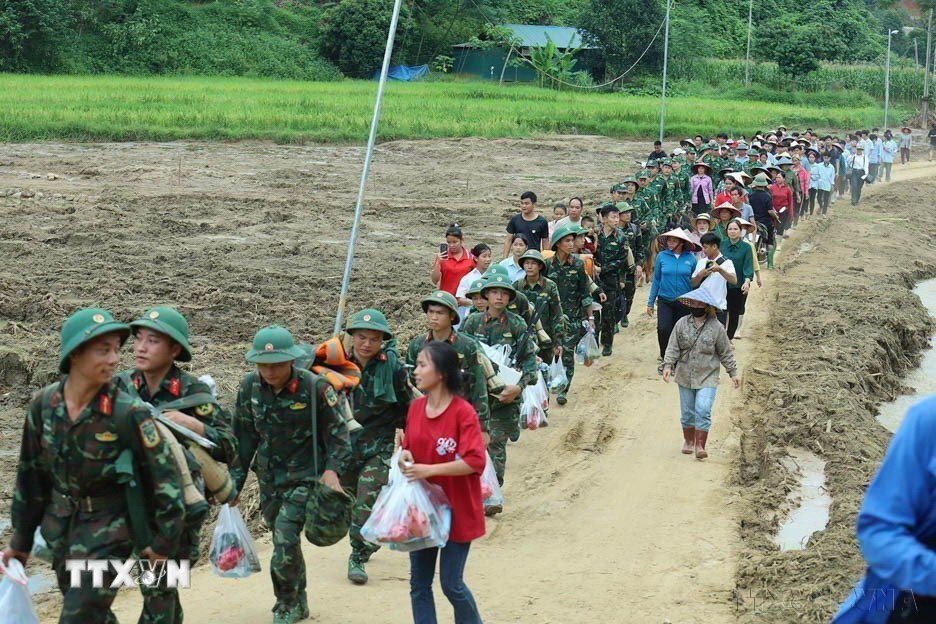 Người dân thôn Làng Nủ, xã Phúc Khánh, huyện Bảo Yên, tỉnh Lào Cai, bịn rịn chia tay các chiến sỹ thuộc Trung đoàn 98, Sư đoàn 316 của Quân khu 2 rút quân khỏi thôn sau 14 ngày tham gia tìm kiếm các nạn nhân mất tích ngày 24/9 vừa qua. (Ảnh: TTXVN phát)