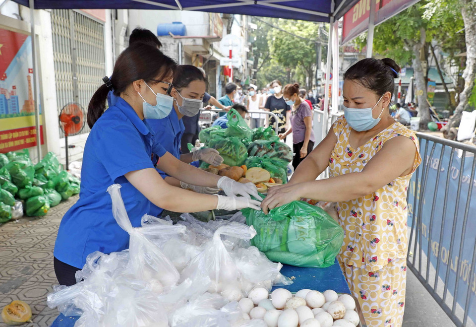 Người lao động khó khăn nhận những túi quà tình nghĩa từ gian hàng 0 đồng. (Ảnh: Trần Việt/TTXVN)