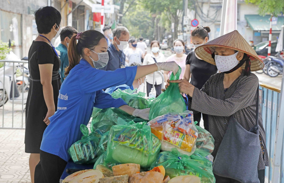 Người lao động khó khăn phường Phúc Xá, quận Ba Đình nhận những túi quà tình nghĩa từ gian hàng 0 đồng. (Ảnh: Trần Việt/TTXVN)
