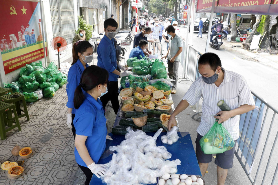 Người lao động khó khăn nhận túi quà tình nghĩa từ gian hàng 0 đồng. (Ảnh: Trần Việt/TTXVN)
