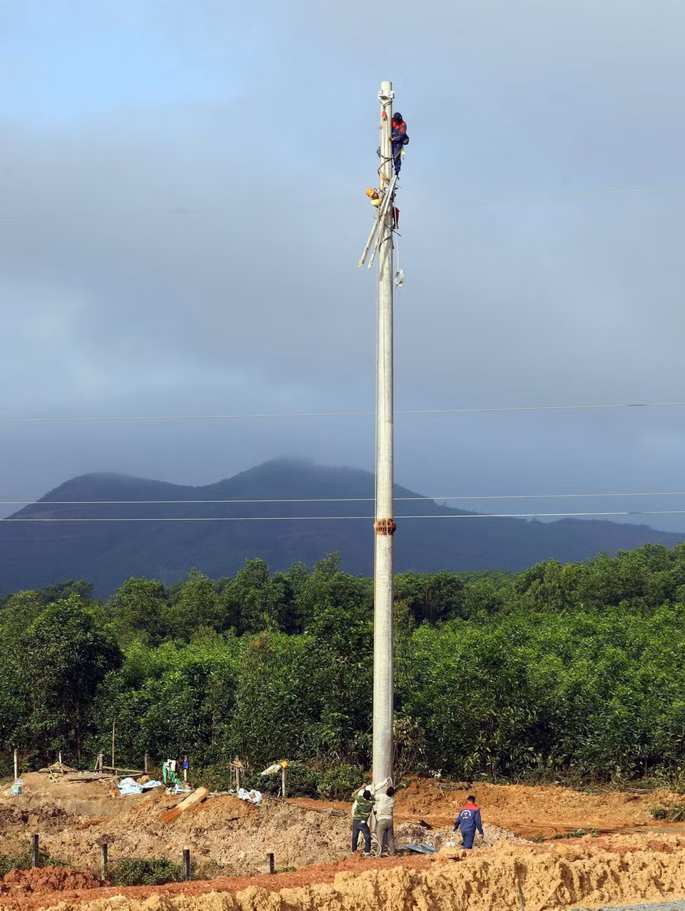 Công nhân đang tiến hành trồng mới cột điện 110Kv để di dời đường điện trên tuyến cao tốc tại địa phận huyện Cẩm Xuyên. (Ảnh: Huy Hùng/TTXVN)