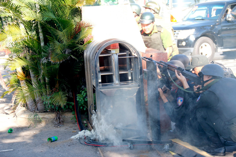 Lực lượng công an tiếp cận xử lý tình huống đối tượng cướp ngân hàng chống trả bằng lựu đạn khói. (Ảnh: Nguyễn Thanh/TTXVN)