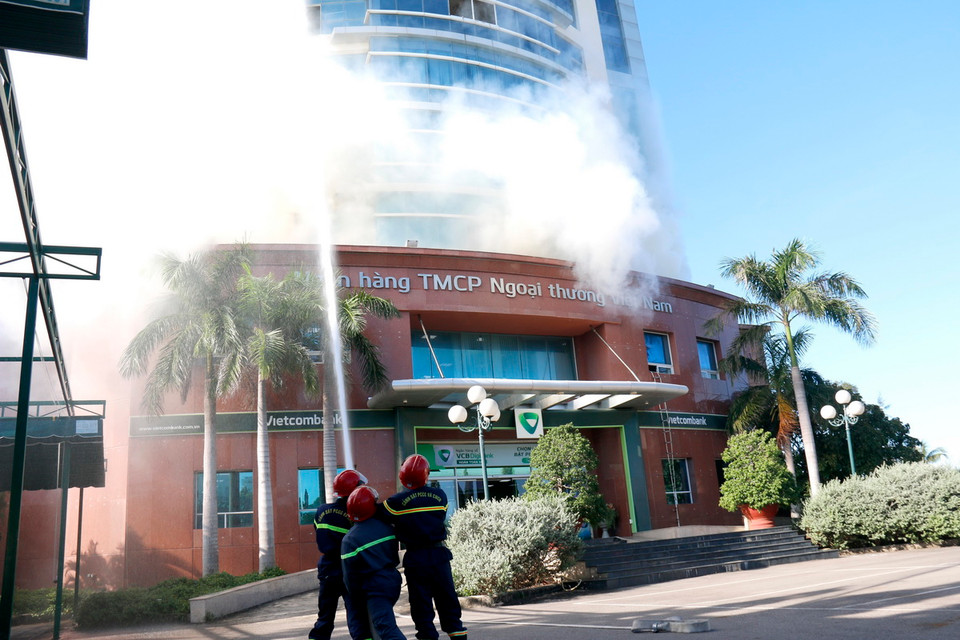 Lực lượng công an chữa cháy xử lý tình huống ngân hàng bị cháy. (Ảnh: Nguyễn Thanh/TTXVN)