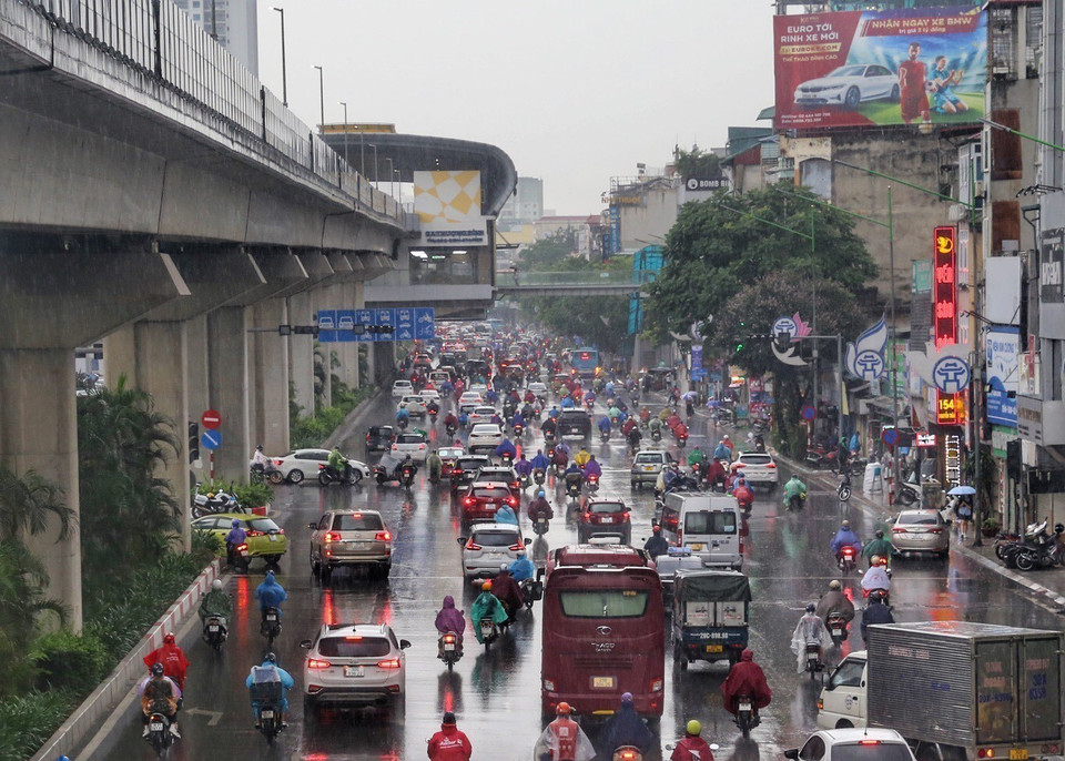 Sáng 6/6, tại Hà Nội, cơn mưa to trước giờ đi làm đã ảnh hưởng đến sinh hoạt của người dân, do trùng giờ cao điểm buổi sáng, nên người và các phương tiện phải di chuyển chậm, nhiều tuyến phố bị ùn tắc. Trên đường Nguyễn Trãi, người dân phải di chuyển chậm. (Ảnh: Tuấn Đức/TTXVN)