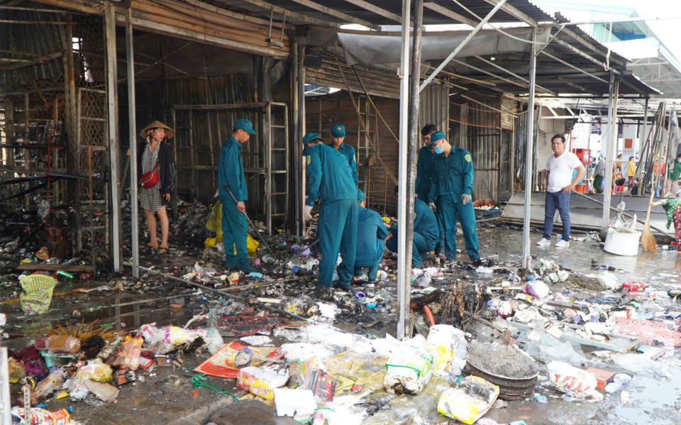 Lực lượng chức năng hỗ trợ người dân khắc phục hậu quả sau vụ cháy. (Ảnh: Nhựt An/TTXVN)