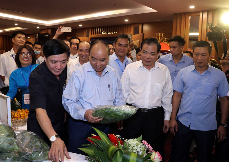 Thủ tướng Nguyễn Xuân Phúc thăm các gian trưng bày nông sản tại hội nghị. (Ảnh: Thống Nhất/TTXVN)