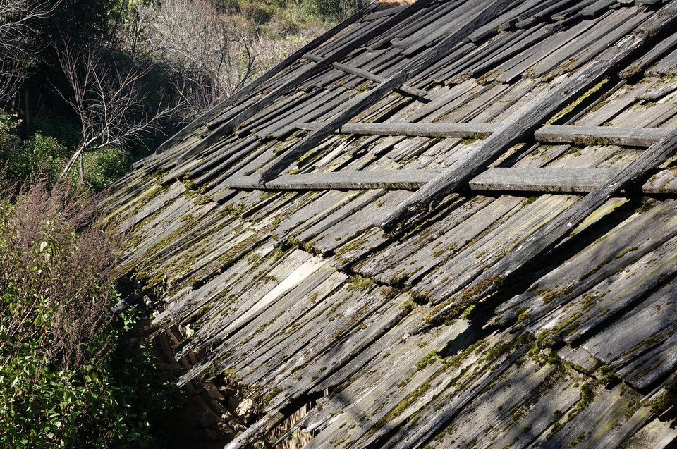 Để mái nhà chắc chắn và đề phòng trường hợp có thể bị dột do mưa bão, người dân thường lót dưới mái nhà một tấm bạt chống thấm nước. Tấm bạt này có thể thay hằng năm, nhưng mái nhà bằng gỗ pơ mu thì sử dụng được vài chục năm, tạo nên nét đặc sắc của bản Lùng Cúng. (Ảnh: Tuấn Anh/TTXVN)