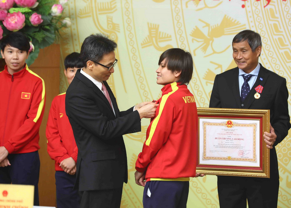  Phó Thủ tướng Vũ Đức Đam gắn Huân chương Lao động hạng Nhì, hạng Ba cho các cầu thủ Đội tuyển Bóng đá Nữ Việt Nam có thành tích xuất sắc. (Ảnh: Phạm Kiên/TTXVN)