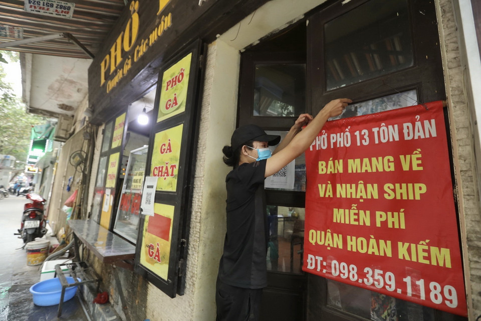  Các cửa hàng ăn, uống chỉ được bán hàng mang về từ 12 giờ trưa 26/12/2021 - ảnh chụp tại địa bàn phường Tràng Tiền, quận Hoàn Kiếm. (Ảnh: Minh Quyết/TTXVN)