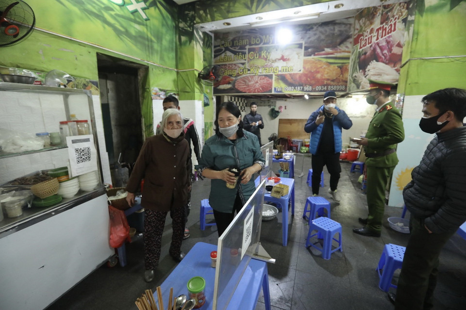  Lực lượng chức năng phường Tràng Tiền (quận Hoàn Kiếm) nhắc nhở các hộ kinh doanh thực hiện theo quy định của quận. (Ảnh: Minh Quyết/TTXVN)