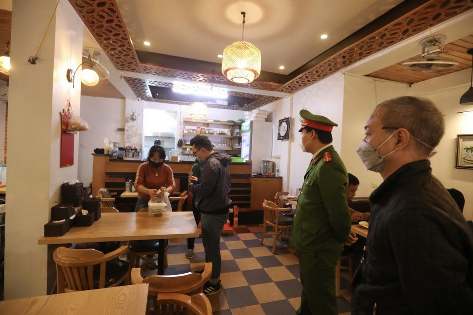  Lực lượng chức năng phường Phan Chu Trinh (quận Hoàn Kiếm) nhắc nhở các hộ kinh doanh thực hiện theo quy định của quận. (Ảnh: Minh Quyết/TTXVN)