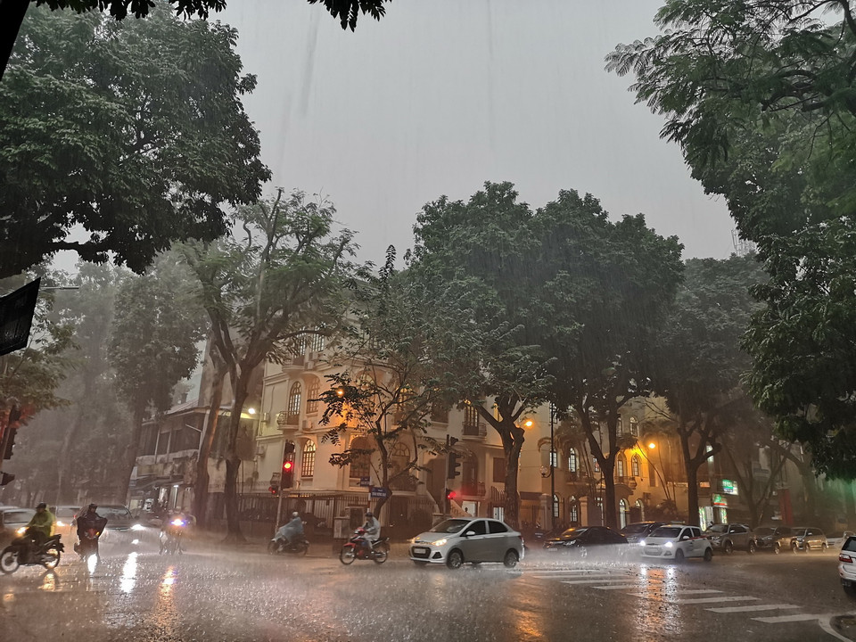 Mưa lớn khiến các phương tiện tham gia giao thông gặp khó khăn. (Ảnh: Thanh Tùng/TTXVN)