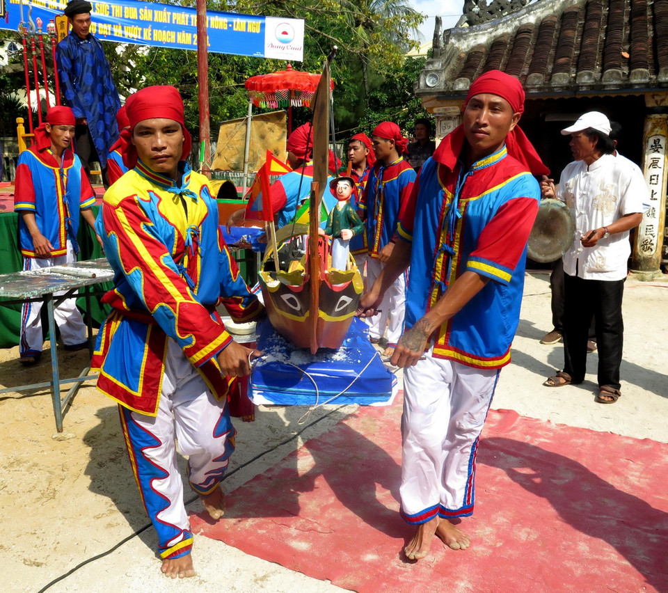 Di chuyển thuyền tế ra biển. (Ảnh: Phước Ngọc/TTXVN)