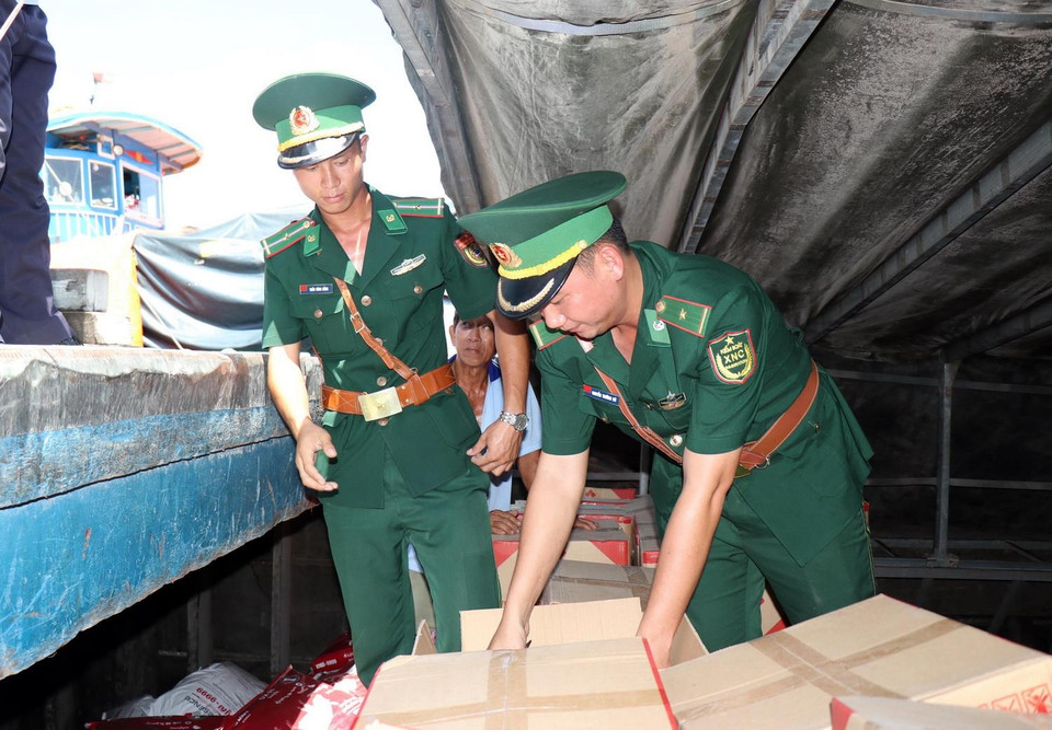 Chiến sỹ Đồn Biên phòng cửa khẩu quốc tế Thường Phước, tỉnh Đồng Tháp phối hợp cùng cán bộ Hải quan kiểm tra hàng hóa trên tàu nhập cảnh. (Ảnh: Xuân Khu/TTXVN)