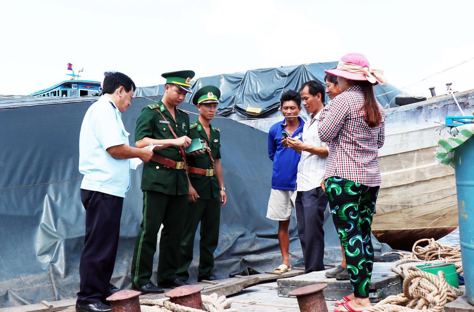 Chiến sỹ Đồn Biên phòng cửa khẩu quốc tế Thường Phước, tỉnh Đồng Tháp phối hợp cùng cán bộ Hải quan kiểm tra hàng hóa trên tàu nhập cảnh. (Ảnh: Xuân Khu/TTXVN)