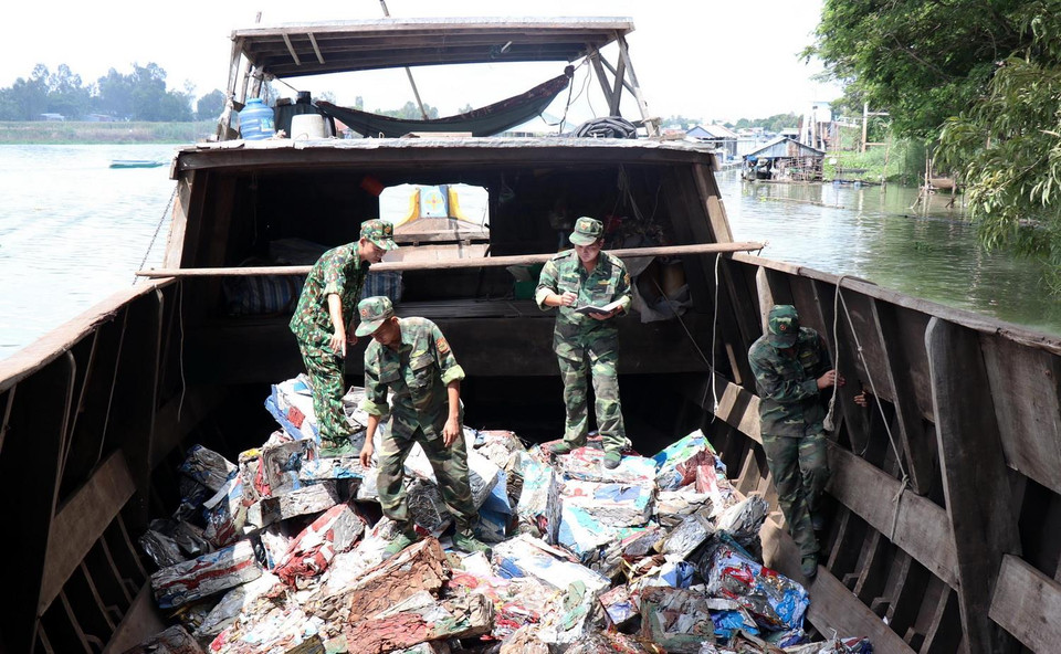 Chiến sỹ Đồn Biên phòng cửa khẩu quốc tế Vĩnh Xương, tỉnh An Giang kiểm tra tang vật vụ vận chuyển phế liệu trái phép qua biên giới. (Ảnh: Xuân Khu/TTXVN)