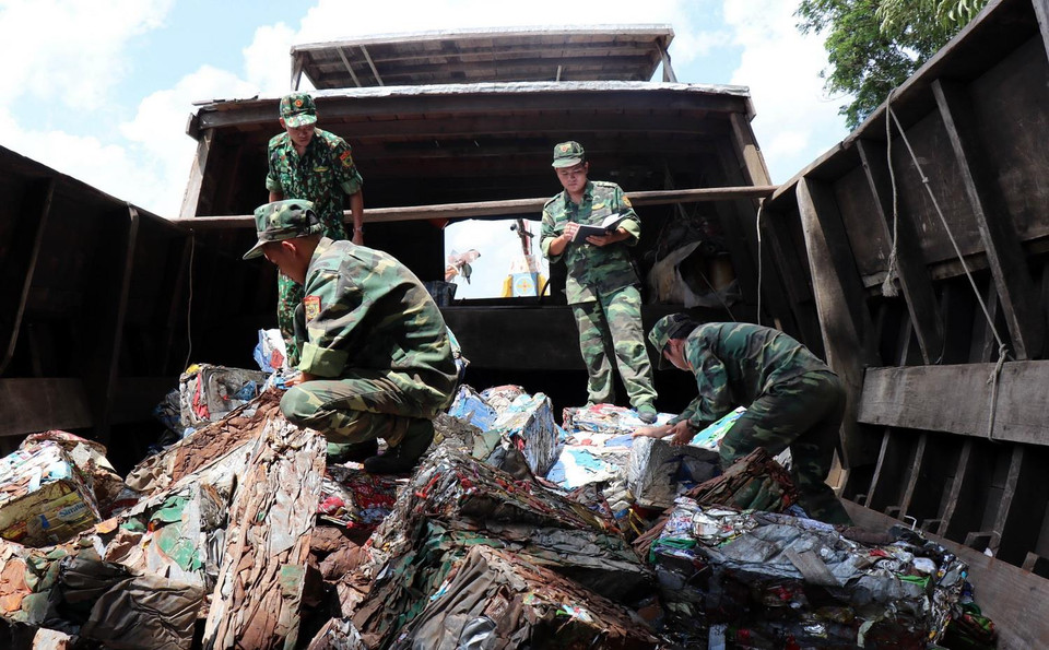Chiến sỹ Đồn Biên phòng cửa khẩu quốc tế Vĩnh Xương, tỉnh An Giang kiểm tra tang vật vụ vận chuyển phế liệu trái phép qua biên giới. (Ảnh: Xuân Khu/TTXVN)